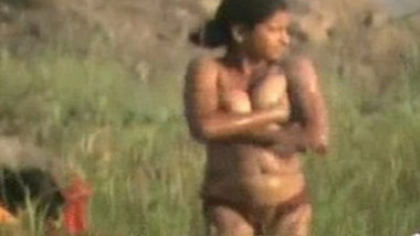 Sexy Indian teen girl is having a bath naked in the field